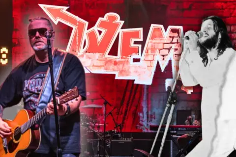 Dwaj wokaliści Dżemu: jeden gra na gitarze, drugi śpiewa do mikrofonu.