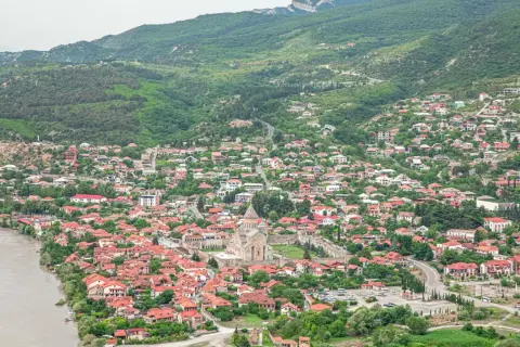 Malownicze miasteczko w Gruzji, z rzeką i zielonymi wzgórzami. Idealne miejsce na podróż, które warto uwzględnić w swoim gruzja przewodnik.