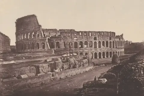 El coliseo romano antes y después: ruinas de un anfiteatro antiguo, con arcos y muros derruidos, evocando su pasado glorioso.