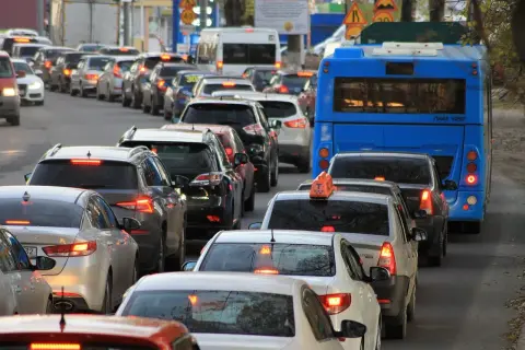 Korek w ruchu drogowym z niebieskim autobusem i wieloma samochodami.