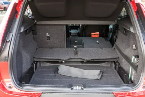 Bagagliaio aperto Volvo XC40, con sedili abbassati per massimizzare le volvo xc40 dimensioni. Si intravede un kit di pronto soccorso.