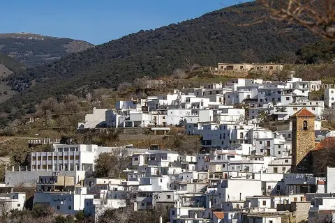 Pueblo blanco en ladera montañosa, ideal para saber qué ver en Almería capital. Destaca su torre campanario.