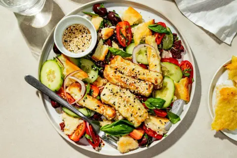 En härlig halloumi sallad med krispiga krutonger, tomater, gurka och oliver. Toppad med sesamfrön.