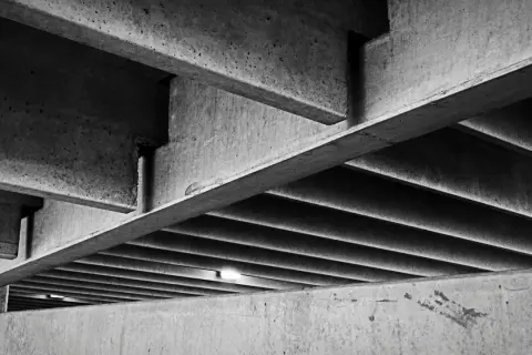 Podkreślone linie i cienie tworzą geometryczny wzór na tle betonowych konstrukcji. Klasy betonu b są tu widoczne w całej okazałości.