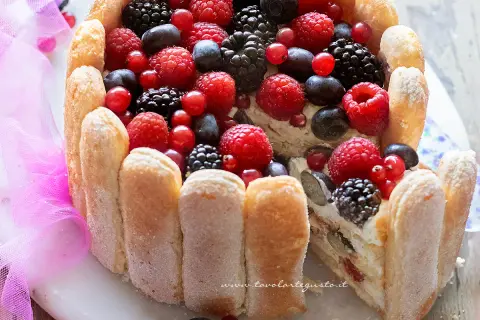 Torta Charlotte ricca di frutti di bosco freschi, con savoiardi croccanti e una crema vellutata. Un dolce estivo perfetto.