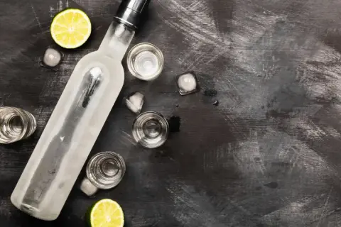 Butelka schłodzonej wódki, kieliszki, lód i limonka. Idealne składniki, by szybko rozrobić spirytus na drinka.