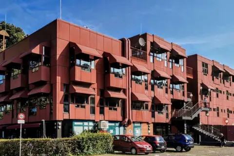 Rotes Gebäude mit markanten Fensterüberdachungen. Vielleicht das Zentrum für das bergischer löwe programm?