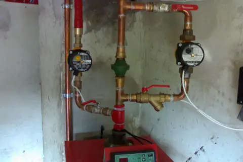 Instalacja grzewcza z pompami obiegowymi i zaworami, pokazująca jak podłączyć bojler z wężownicą.