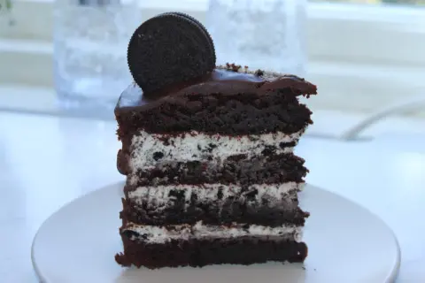 En bit chokladkaka med lager av krämig fyllning och krossade oreos. En hel oreo kex toppar denna läckra oreo tårta.