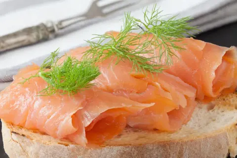 Kanapka z wędzonym łososiem i koperkiem. Czy łosoś wędzony jest zdrowy? Tak, to pyszna i bogata w kwasy omega-3 przekąska.