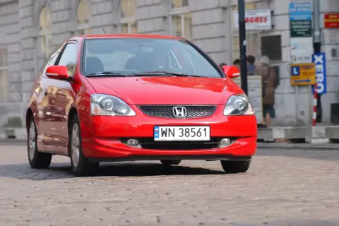 Czerwony Honda Civic VII, gotowy do wymiany żarówki mijania.