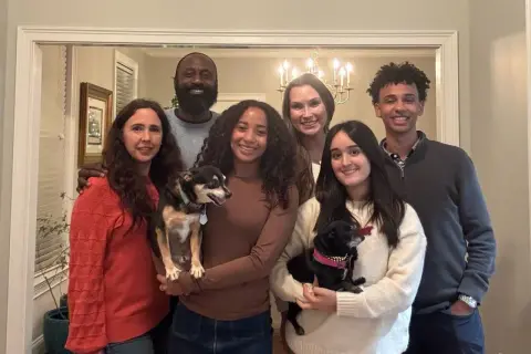 La familia anfitriona posa sonriente con sus dos perros.