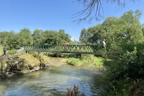 Ludzie na moście nad rzeką, odkrywający malownicze słowacki raj trasy.