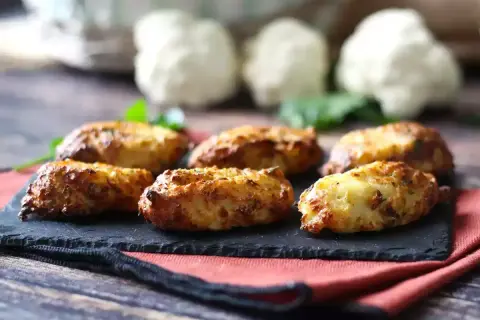 Krispiga blomkålsbiffar på en svart skifferplatta, ett perfekt middagstips för en hälsosam och god måltid.