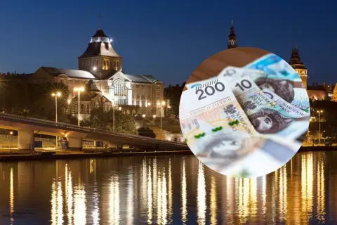 Szczecin nocą, most, rzeka i polskie banknoty.