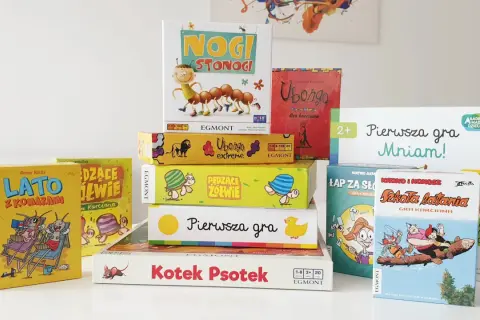 Stos kolorowych pudełek z grami planszowymi, idealnych na szybkie gry planszowe. Widać m.in. "Nogi Stonogi", "Ubongo" i "LATO z Komarami".