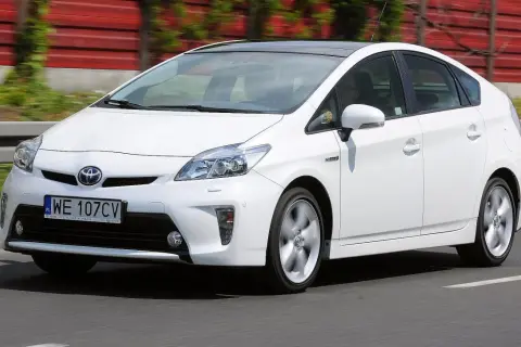 Biały Toyota Prius 3 na drodze, z widocznym numerem rejestracyjnym WE 107CV.