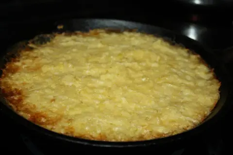 En gyllene potatiskaka med parmesan, nybakad i gjutjärnspanna. Låter det inte gott?