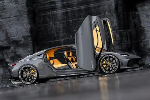 Szary Koenigsegg Gemera z otwartymi drzwiami, żółtym wnętrzem i złotymi zaciskami hamulcowymi. Czy to najszybsze auto na świecie?