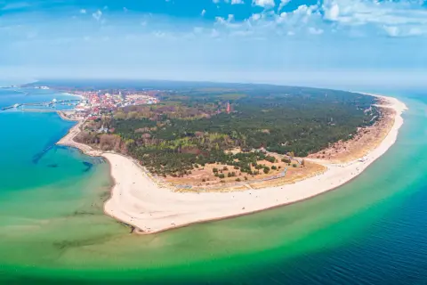 Półwysep Helski zachwyca szerokością plaż i lasów. Widok na miasteczko i turkusowe morze.