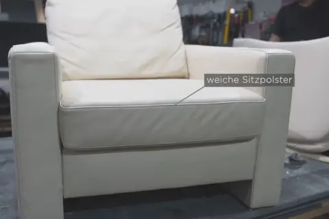 Ein weißer Ledersessel mit weichen Sitzpolstern. Hier wird gezeigt, wie man den Federkern eines Sofas reparieren kann.