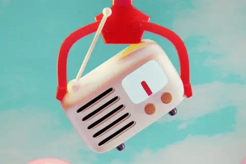 Ein roter Greifarm hebt ein Retro-Radio hoch. Vielleicht spielt es den meist gecoverten Song aller Zeiten.