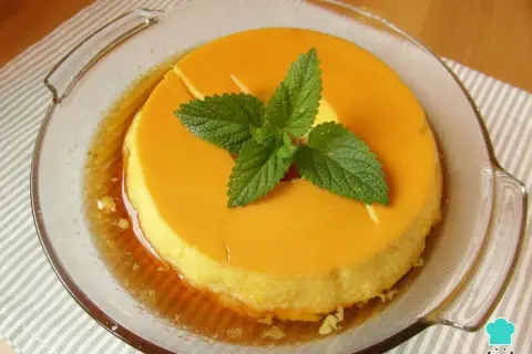 Delicioso flan de leche condensada al baño maría, decorado con hojas de menta fresca.