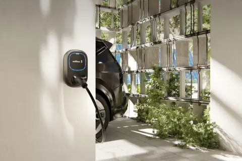 Wallbox: la stazione di ricarica per auto elettriche, qui vista in un contesto moderno e verdeggiante.