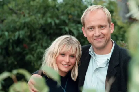 Ebba Hultkvist Stragne med sitt barn, en glad stund utomhus bland grönska.