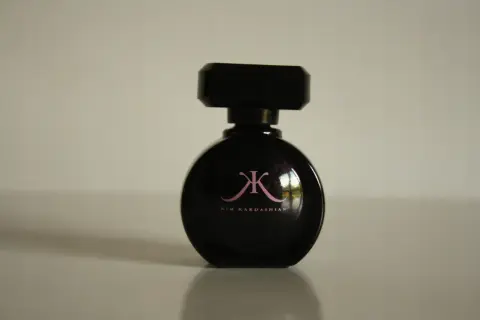 Czarna butelka perfum Kim Kardashian z różowym logo.