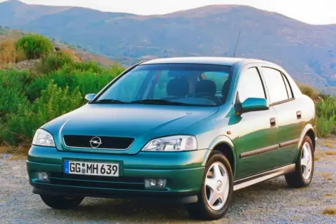 Zielony Opel Astra Classic 1999 na tle górskiego krajobrazu.