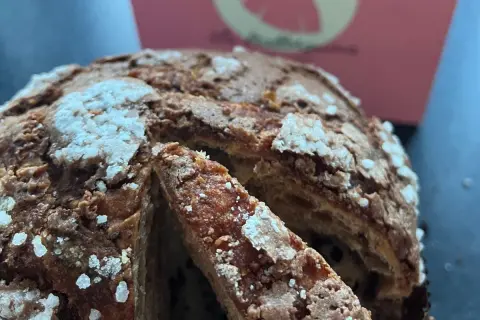 Un delicioso panettone con trozos de chocolate, listo para ser disfrutado. Así se come el panettone, en rebanadas esponjosas.