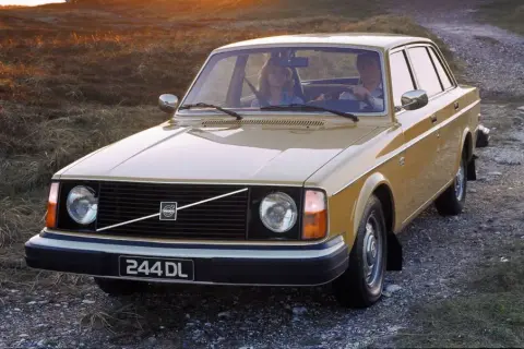 En gul Volvo 244 DL kör på en grusväg i solnedgången. Hur många Volvo 240 tillverkades? Över 2,8 miljoner.