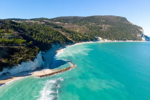Spiaggia di Numana con scogliere bianche, mare turchese e pineta. Ecco cosa vedere a Numana per un panorama mozzafiato.
