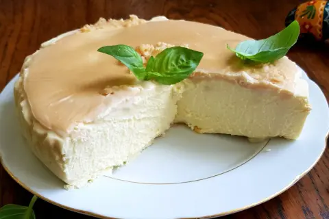 Puszysty keto sernik na zimno z delikatną polewą karmelową i listkami bazylii. Idealny deser dla miłośników niskowęglowodanowych słodkości.