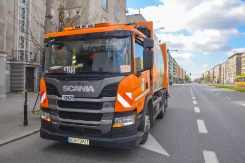Pomarańczowy śmieciarka Scania na ulicy w Warszawie. Zakaz wjazdu tirów w centrum miasta nie dotyczy pojazdów komunalnych.