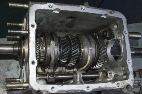 Vue détaillée d'une boîte de vitesses ouverte, montrant les engrenages et les synchroniseurs. Le mécanisme de synchro boite de vitesse est visible.