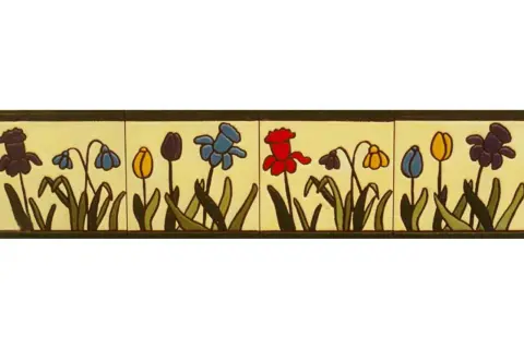 Una cenefa que es un borde decorativo con flores de estilo rústico en tonos morado, azul, amarillo y rojo, sobre un fondo crema.