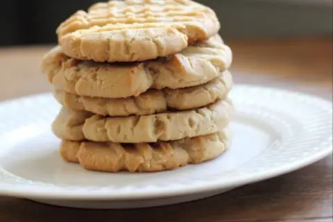 Una pila de galletas de mantequilla de maní, algunas de las galletas más famosas, en un plato blanco.