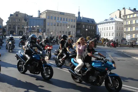 Zloty motocyklowe w mieście. Grupa motocyklistów w kaskach i skórzanych ubraniach przemierza ulicę na swoich maszynach.