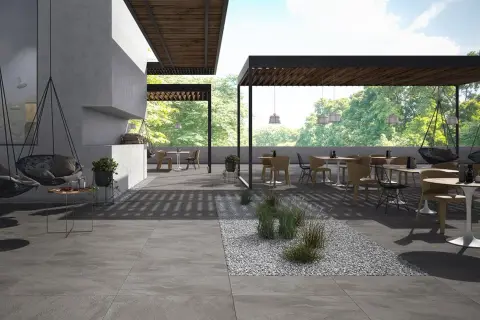 Spazio esterno moderno con tavoli, sedie e altalene, pavimentato con eleganti mattonelle per esterni grigie.