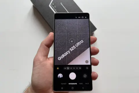 Ręka trzyma telefon Samsung Galaxy S25 Ultra z otwartą aplikacją aparatu. Widoczne opcje: portret, fotografia, wideo. Dowiedz się, jak ustawić aparat w telefonie Samsung.