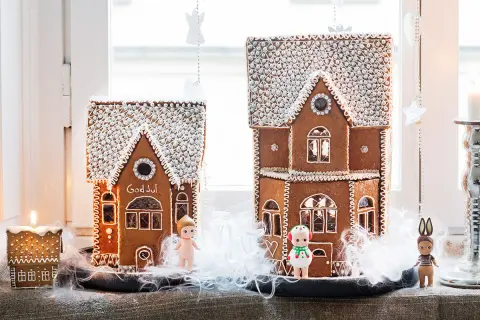 Två pepparkakshus med "God Jul" på det ena. Perfekt mall att skriva ut för att baka egna. Små figurer står framför.
