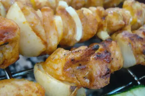 Szaszłyki z kurczaka i cebuli, idealnie przypieczone na grillu. Dowiedz się, jak pokroić cebulę do szaszłyków, by uzyskać taki efekt.