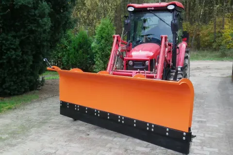 Czerwony traktor z zamontowanym pomarańczowym pługiem do odśnieżania, gotowy do pracy zimą.