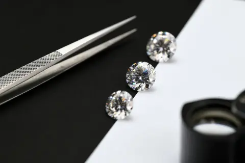 Pinzas y diamantes sobre fondo blanco y negro. Aprende como saber si un mineral es real.