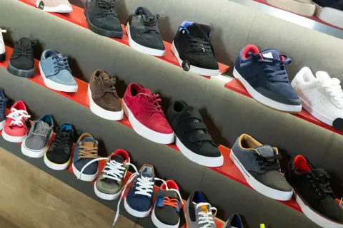 Scaffali pieni di sneakers, tra cui modelli nira rubens, in vari colori e stili, pronte per essere indossate.