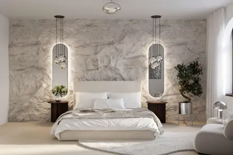Moderne Schlafzimmer Style Ideen: Steinwand, Spiegel mit Beleuchtung, bequemes Bett und ein Olivenbaum im Topf schaffen eine luxuriöse Atmosphäre.