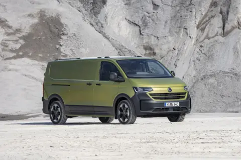 Un furgone Volkswagen Transporter color verde oliva, con un design moderno e robusto, pronto per ogni avventura. Le sue dimensioni sono perfette per il trasporto.