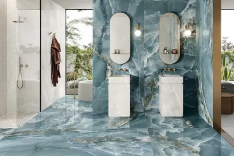 Un lussuoso bagno con pavimenti e pareti in onice blu, due lavabi moderni e una doccia con piastrelle bianche.